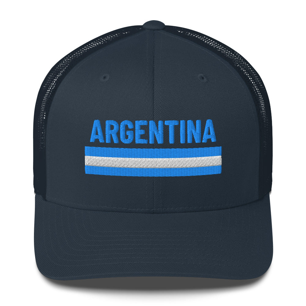 Trucker cap beige con palabra bordada “Argentina” en azul celeste, diseño limpio con orgullo nacional.
