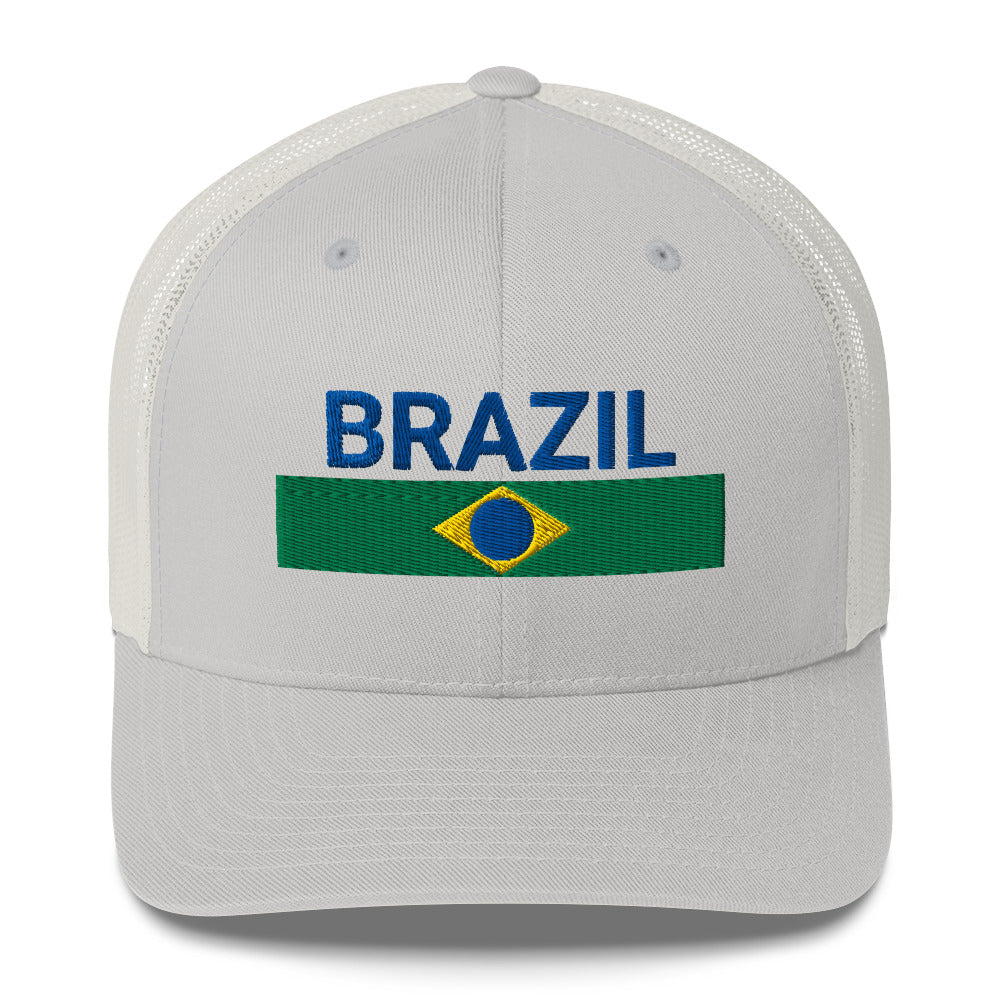 Gorra trucker con texto bordado “Ordem e Progresso” en verde, amarillo y azul sobre fondo beige.